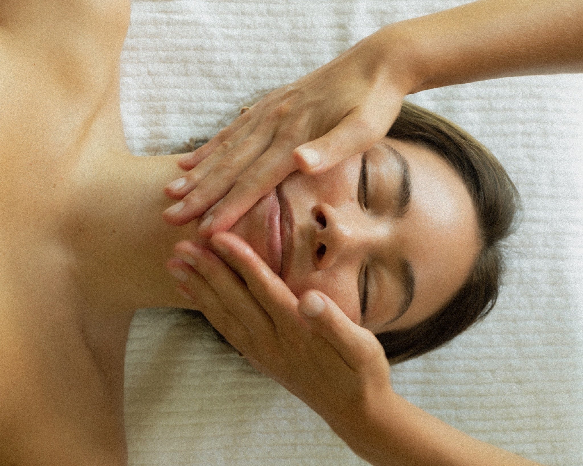 Women getting facial massage with oil cleanser products